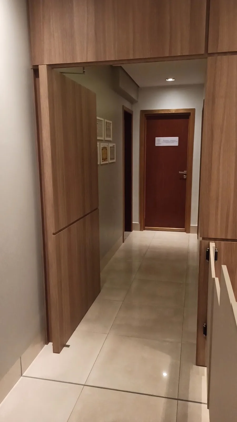 Corredor com painéis de madeira e porta ao fundo